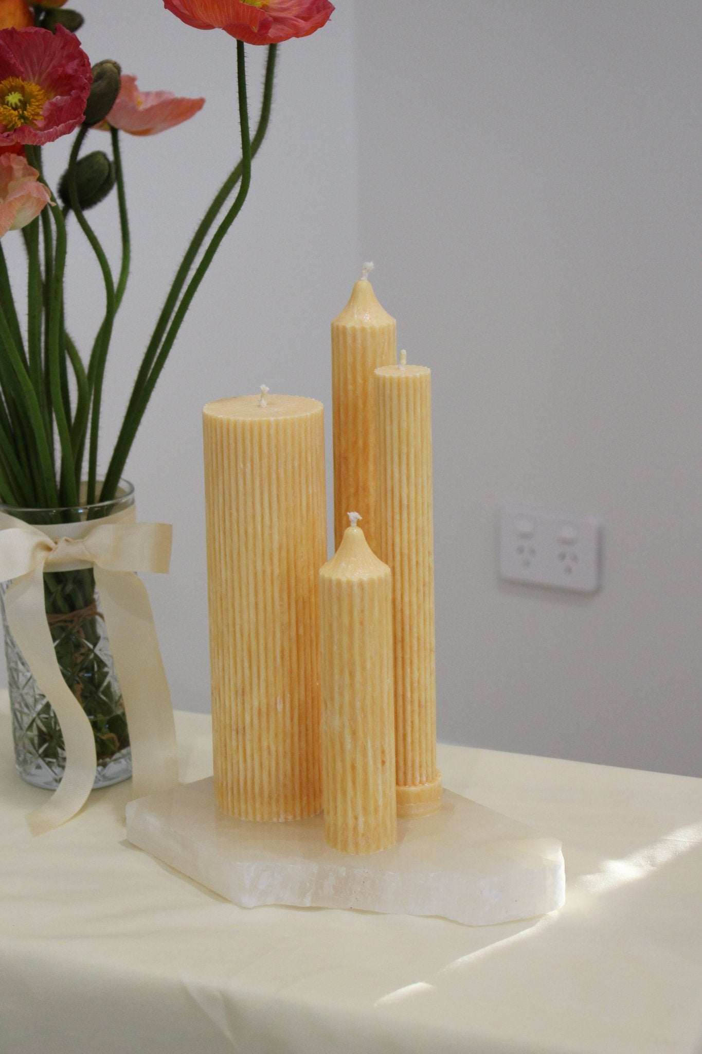 Arrangement of fluted pillar candles including Allegra all in Marigold (pastel orange) colour. This arrangement is the New Heights Bundle.