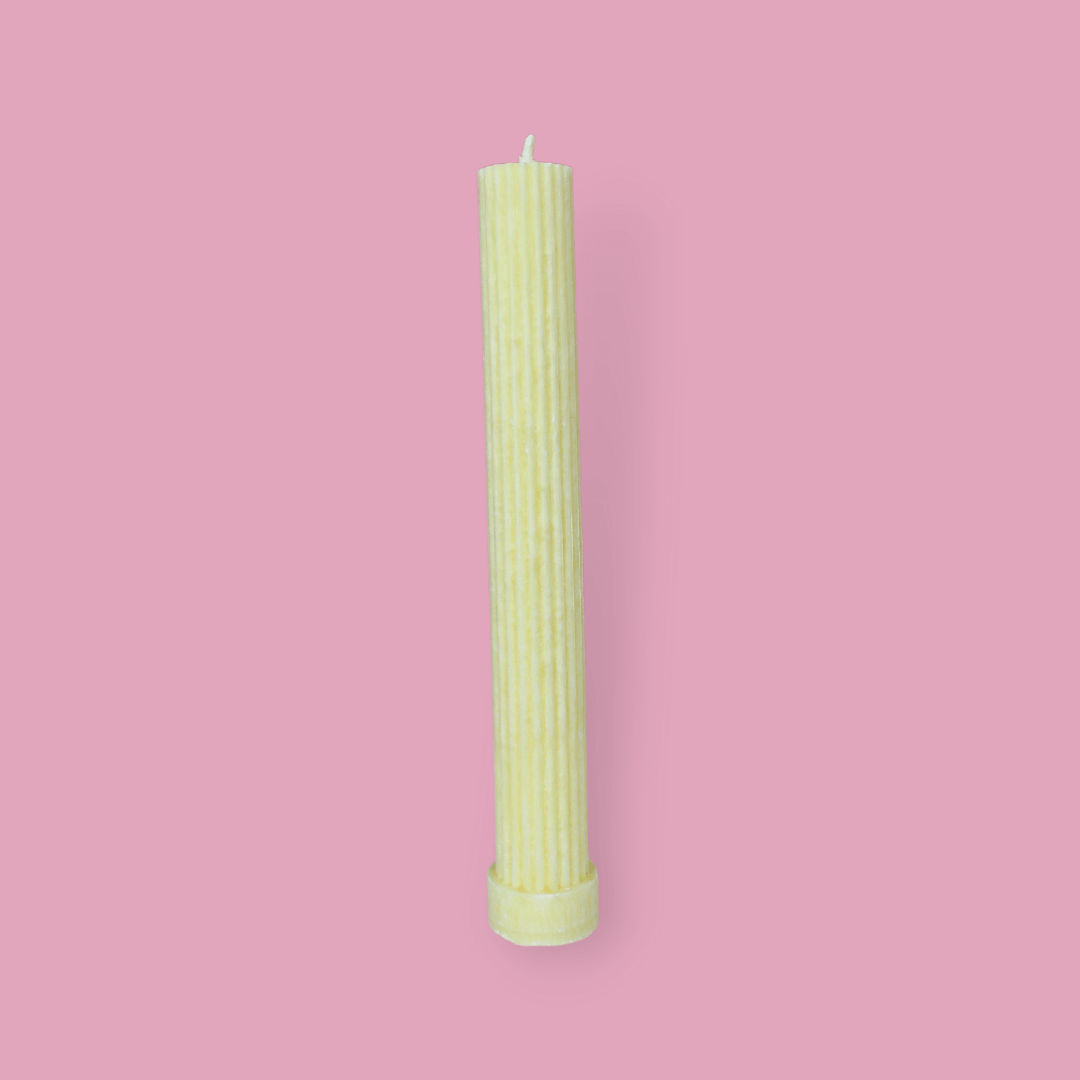 Allegra fluted pillar candle in 27cm height and flat base shown in frangipani (yellow) colour. 