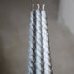 Twisty Ariel taper candles in three shades of grey shown together.