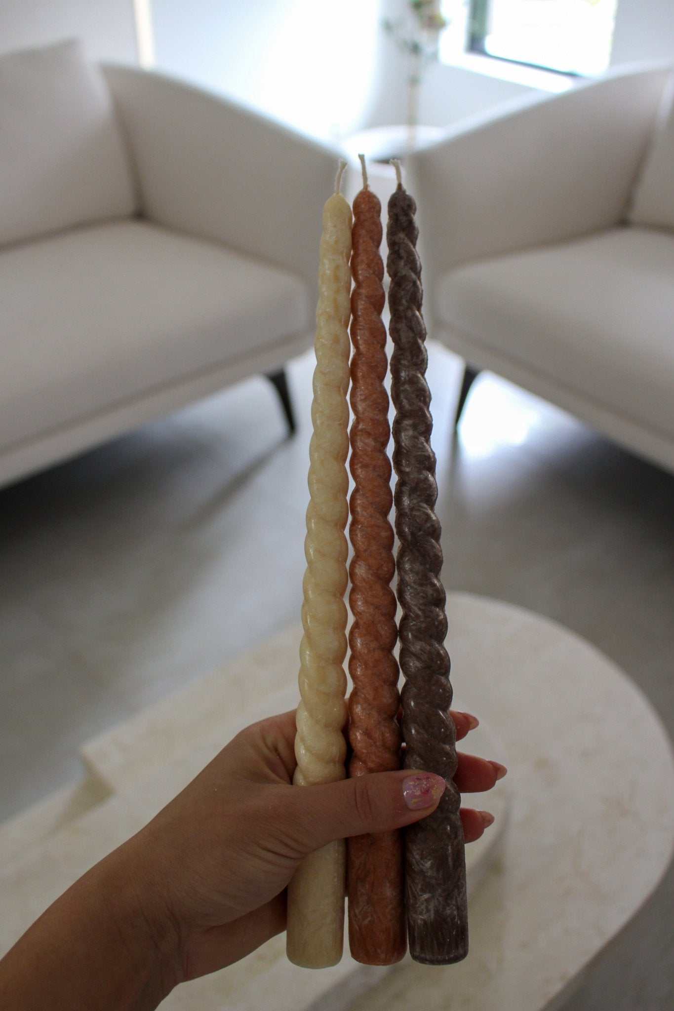 Twisty Ariel taper candles in White Onyx (cream), Rust (burnt orange) and Cacao (chocolate brown) shown together.