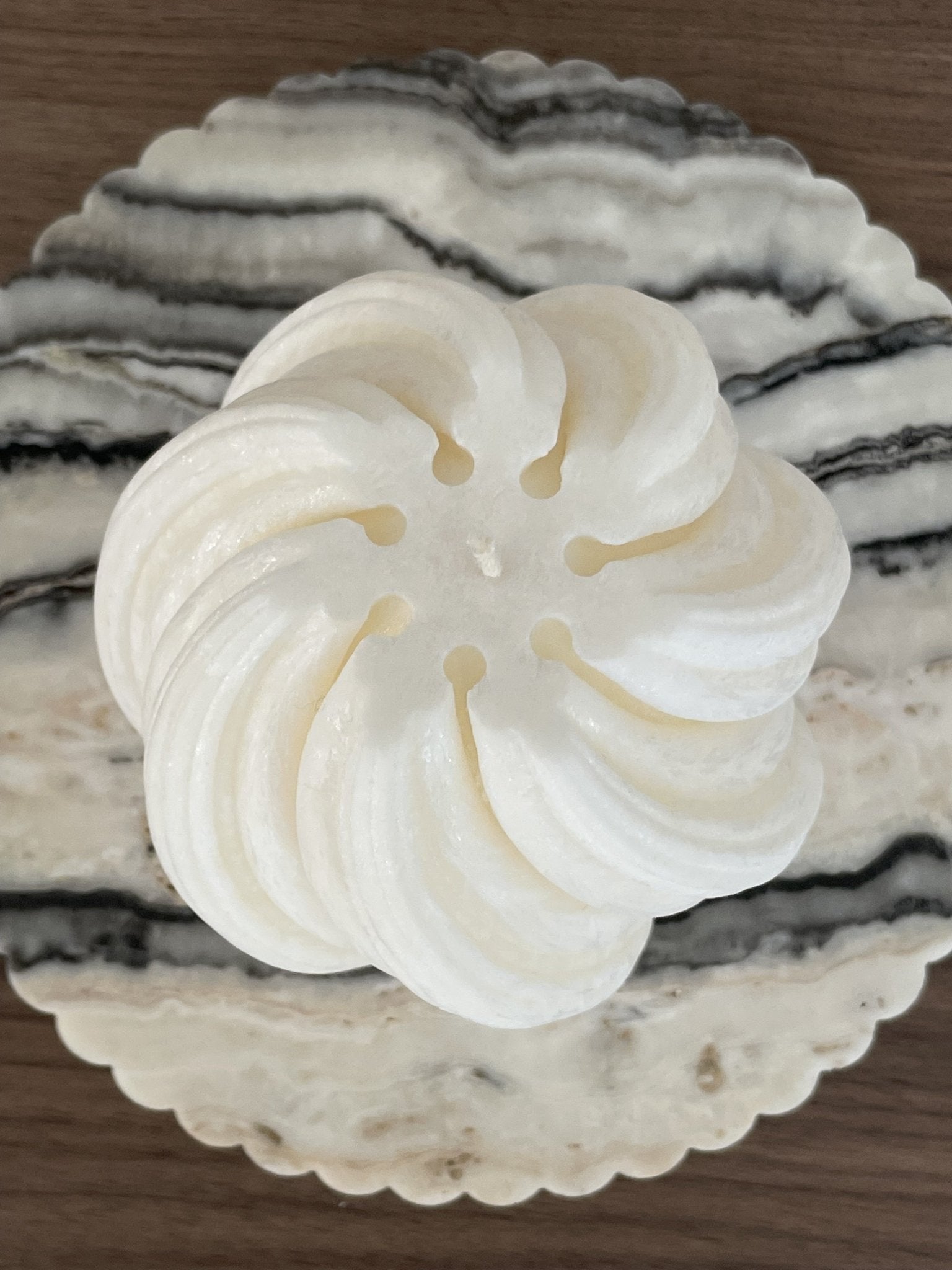 Top view of sculptural Aurora candle in Ivory (white) colour sitting on a piece of marble.