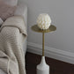 Sculptural Brydie candle in Ivory (white) sitting on a brass and marble side table. This candle has a smooth braid-like exterior similar to a thick knitted wool blanket.