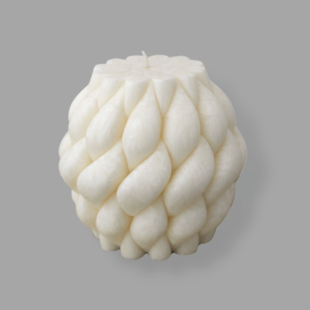 Sculptural Brydie candle in Ivory (white). This candle has a smooth braid-like exterior similar to a thick knitted wool blanket.