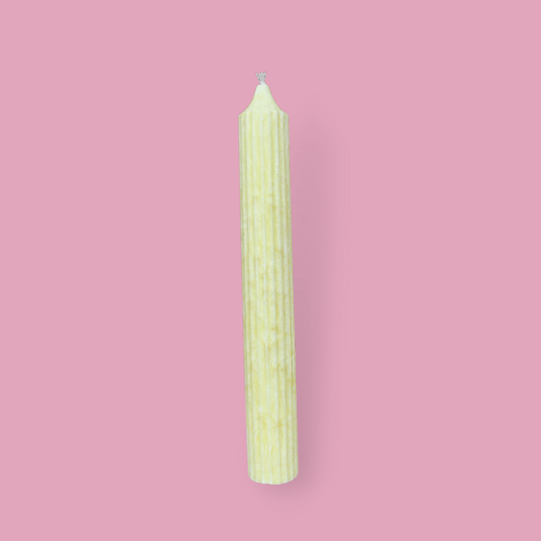 Tall pillar candle with a pointed top Elia in Frangipani (pastel yellow) colour.