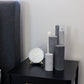 Arrangement of fluted pillar candles shown in grey shades.