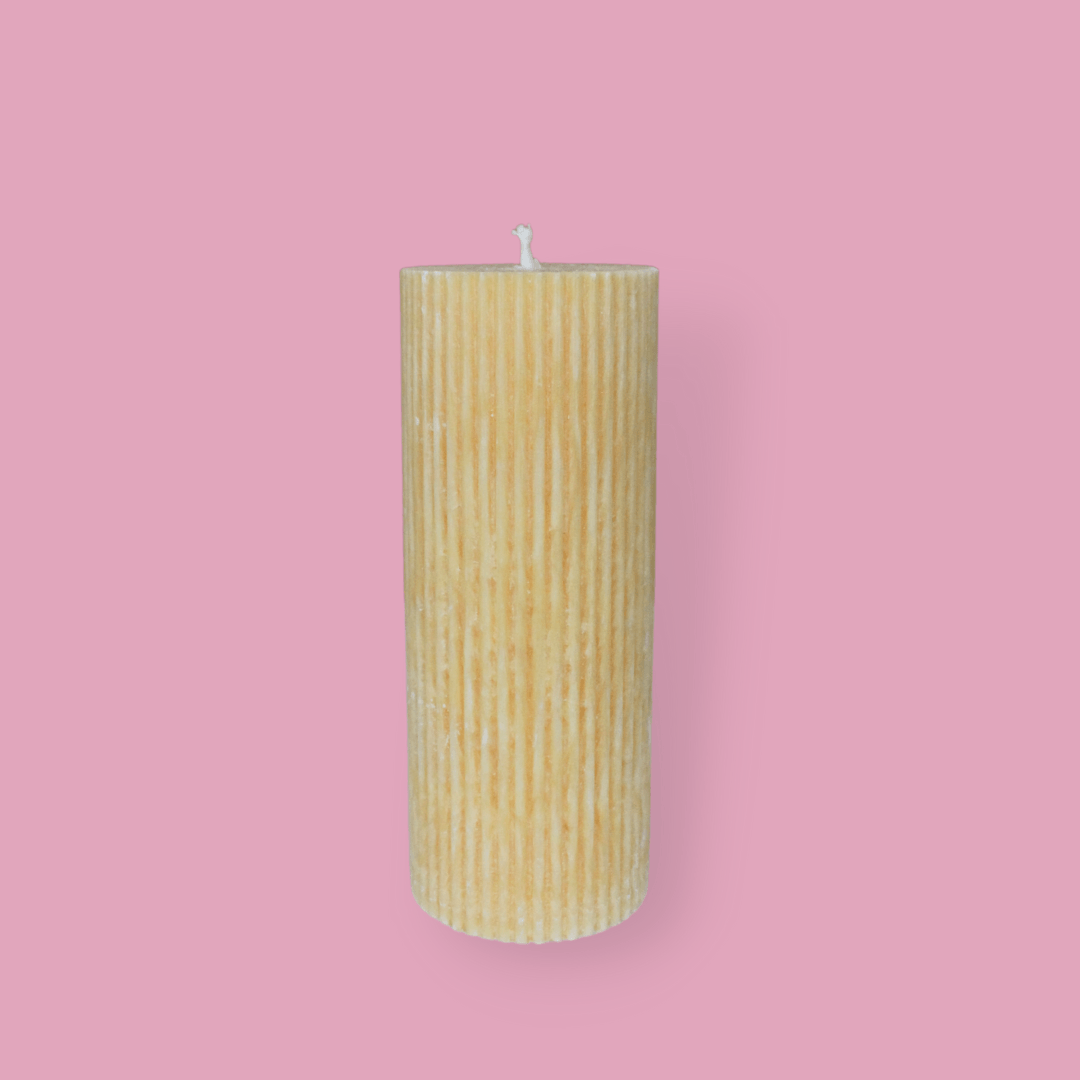 Medium height thick fluted pillar candle Marlie in Marigold (pastel orange) colour. This standalone pillar candle has a flat top and base.