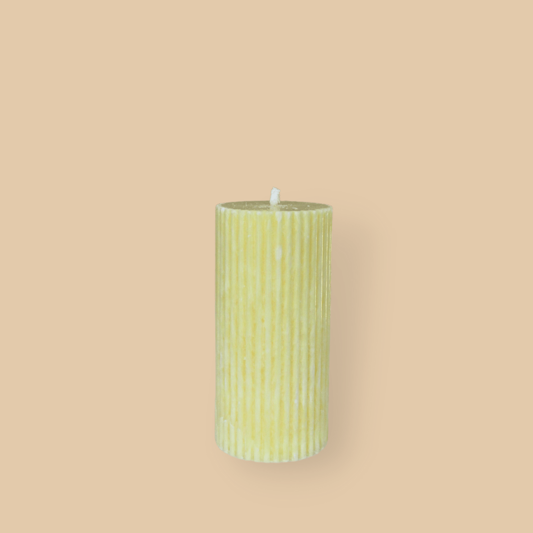 Short thick fluted pillar candle Sasha in Frangipani (pastel yellow) colour. This standalone pillar candle has a flat top and base.