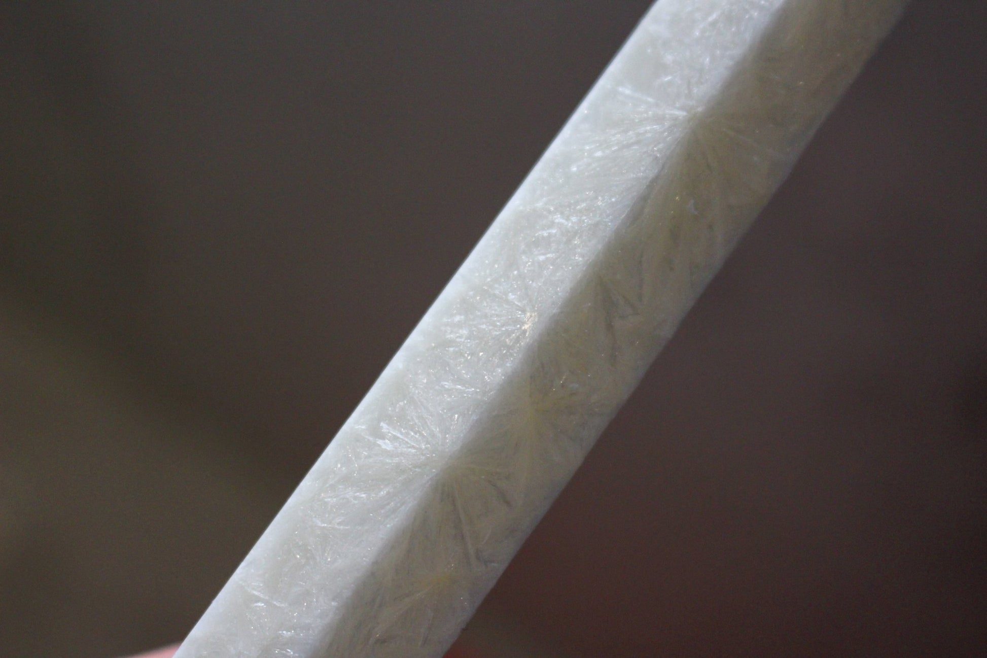 Close up of the smooth marbled texture of the Shiloh dinner taper candle in Ivory (white) colour.